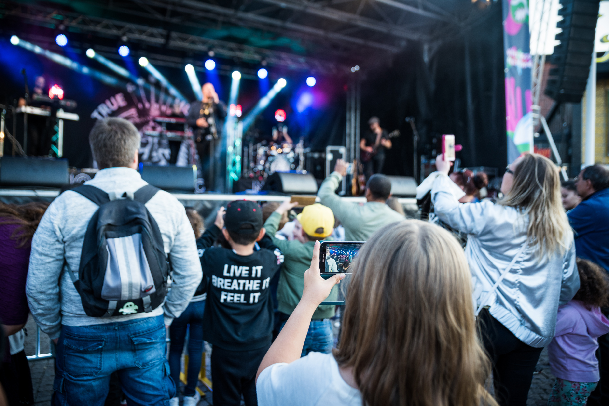 Barn som fotar artist på scen.