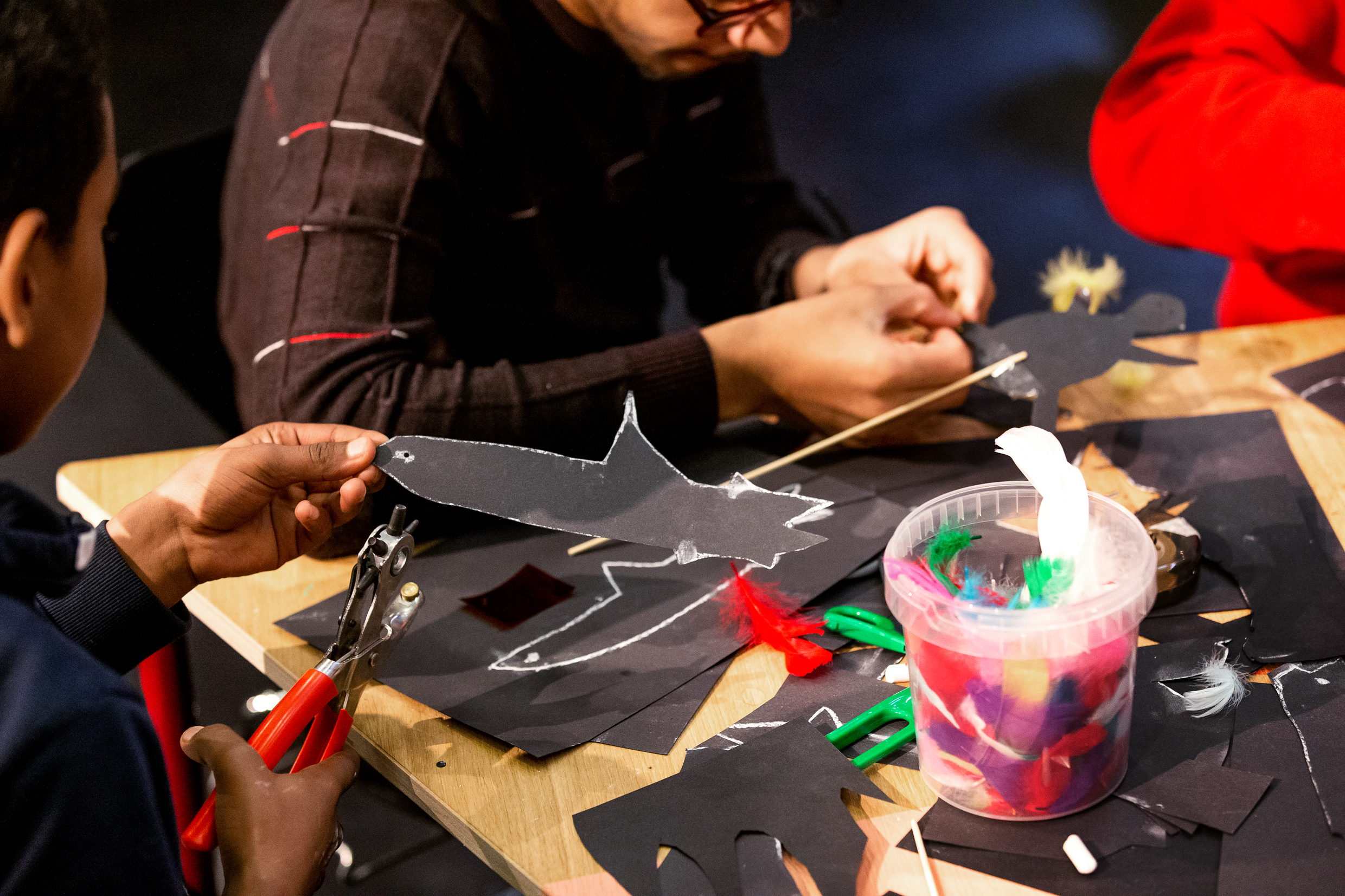 Barn och vuxna skapar figurer tillsammans. 