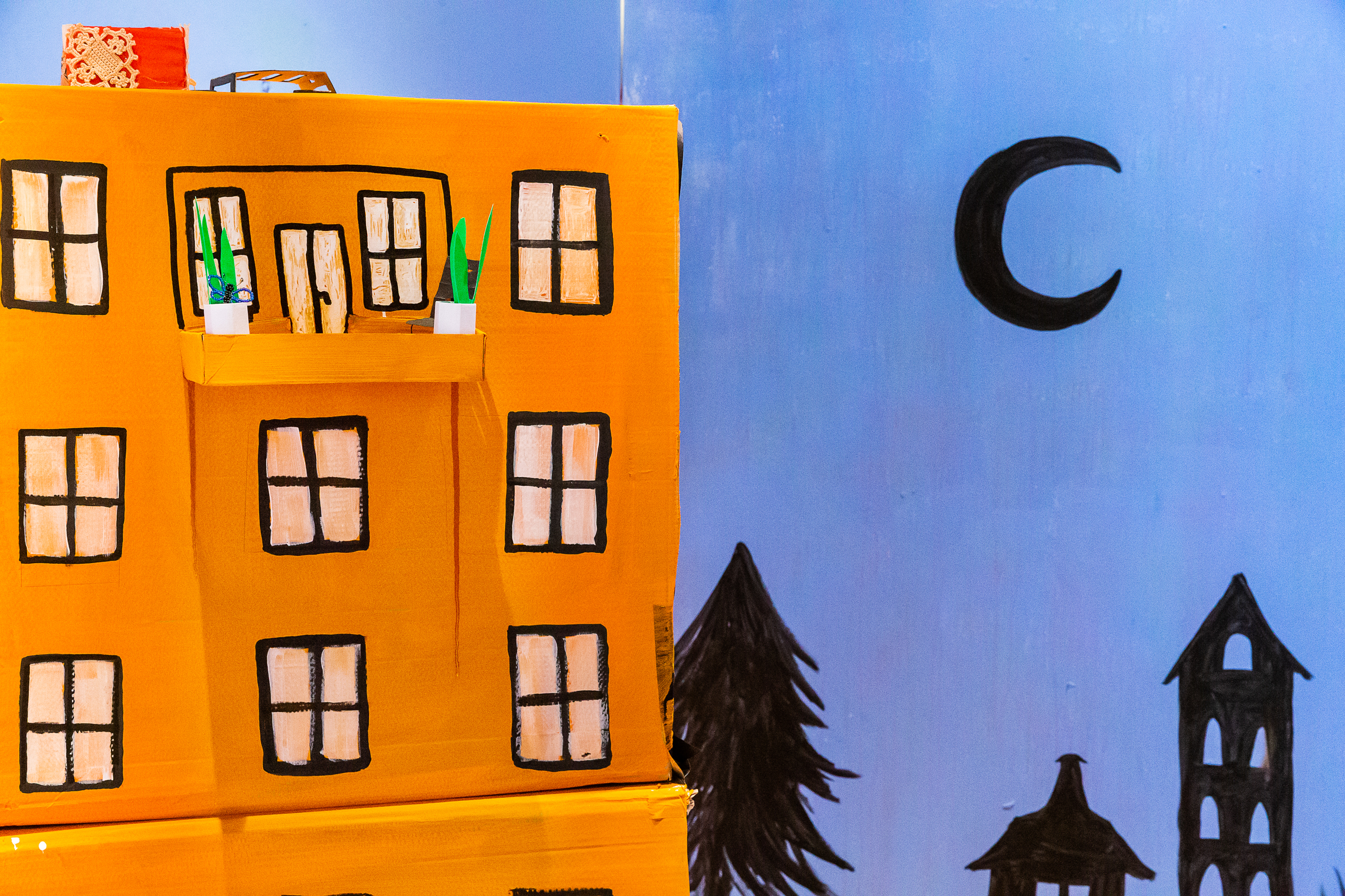 Ett hus i miniatyr med blå himmel och en måne i bakgrunden. 