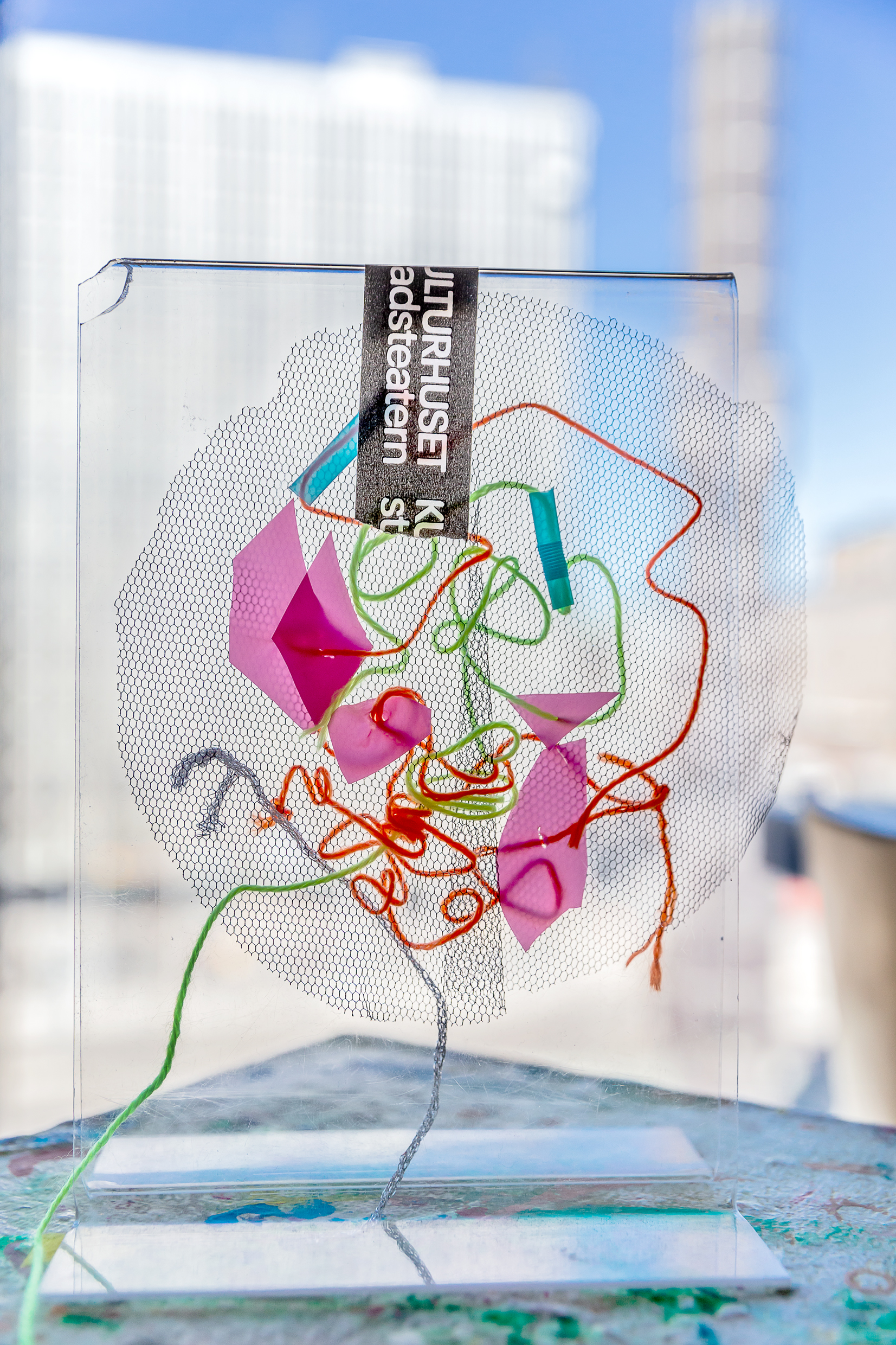 Ett mönster av trådar, tygbitar och pappersbitar. 