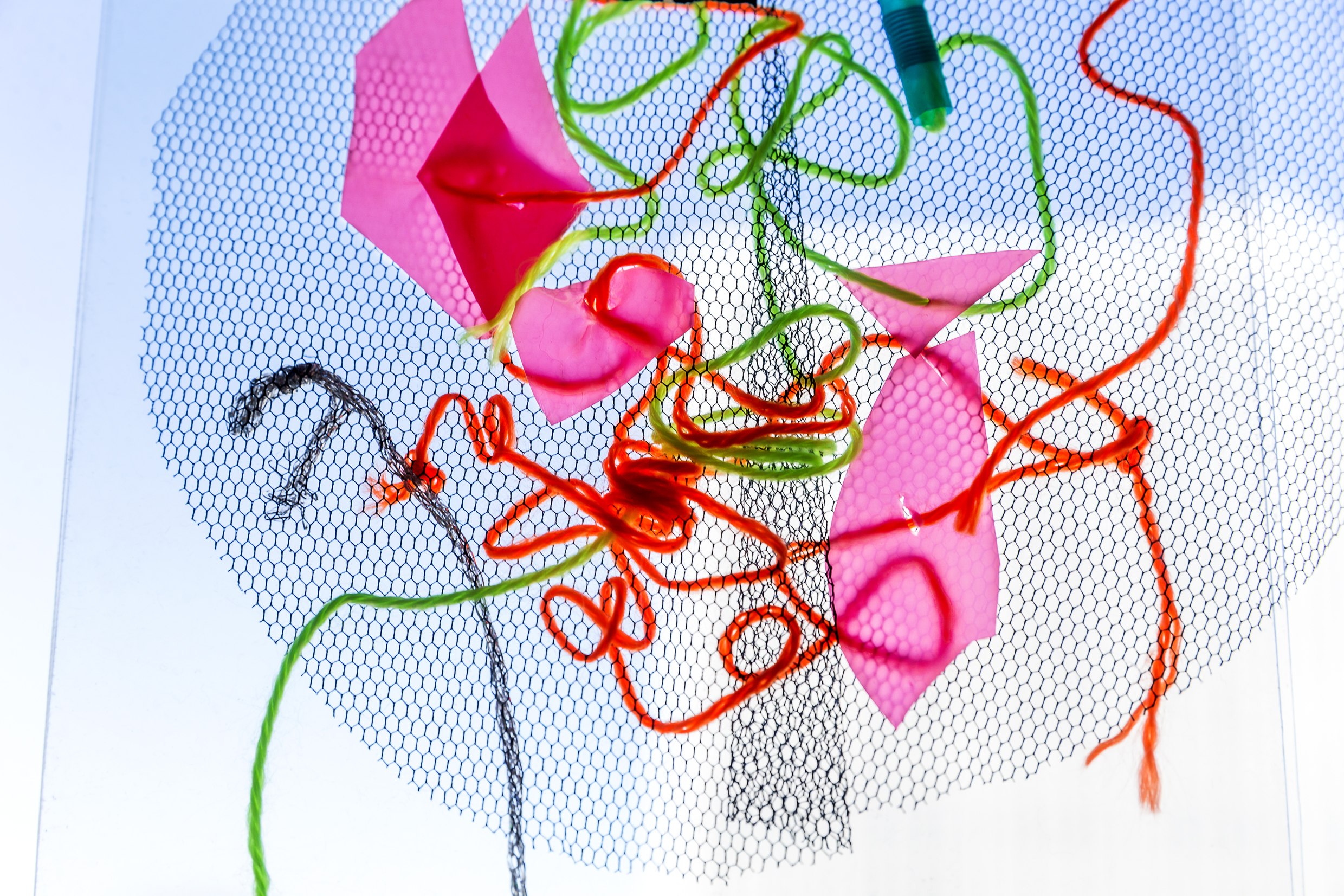 Ett mönster av trådar, tygbitar och pappersbitar. 