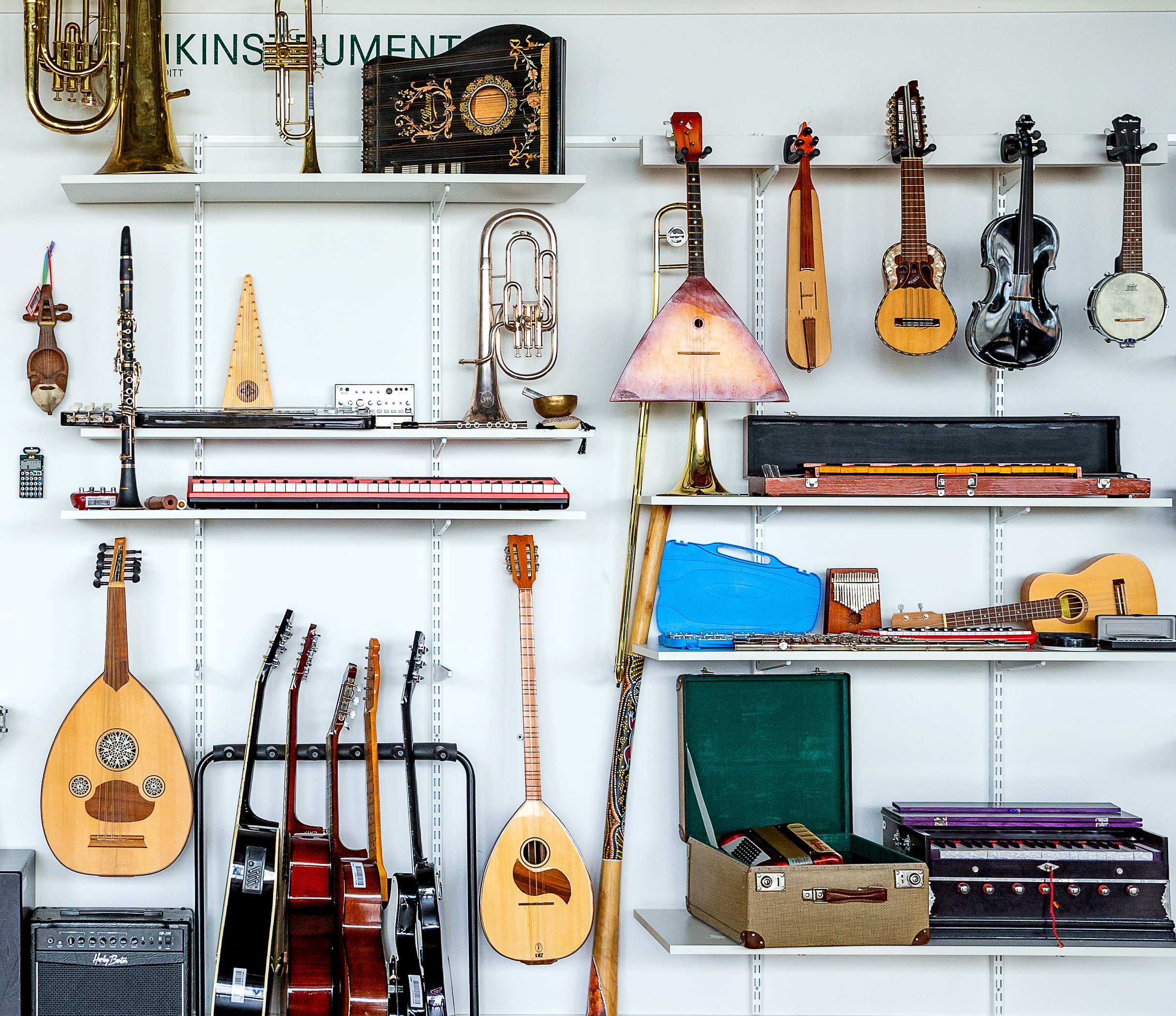 Musikinstrument som hänger på en vägg och ligger på hyllor. 