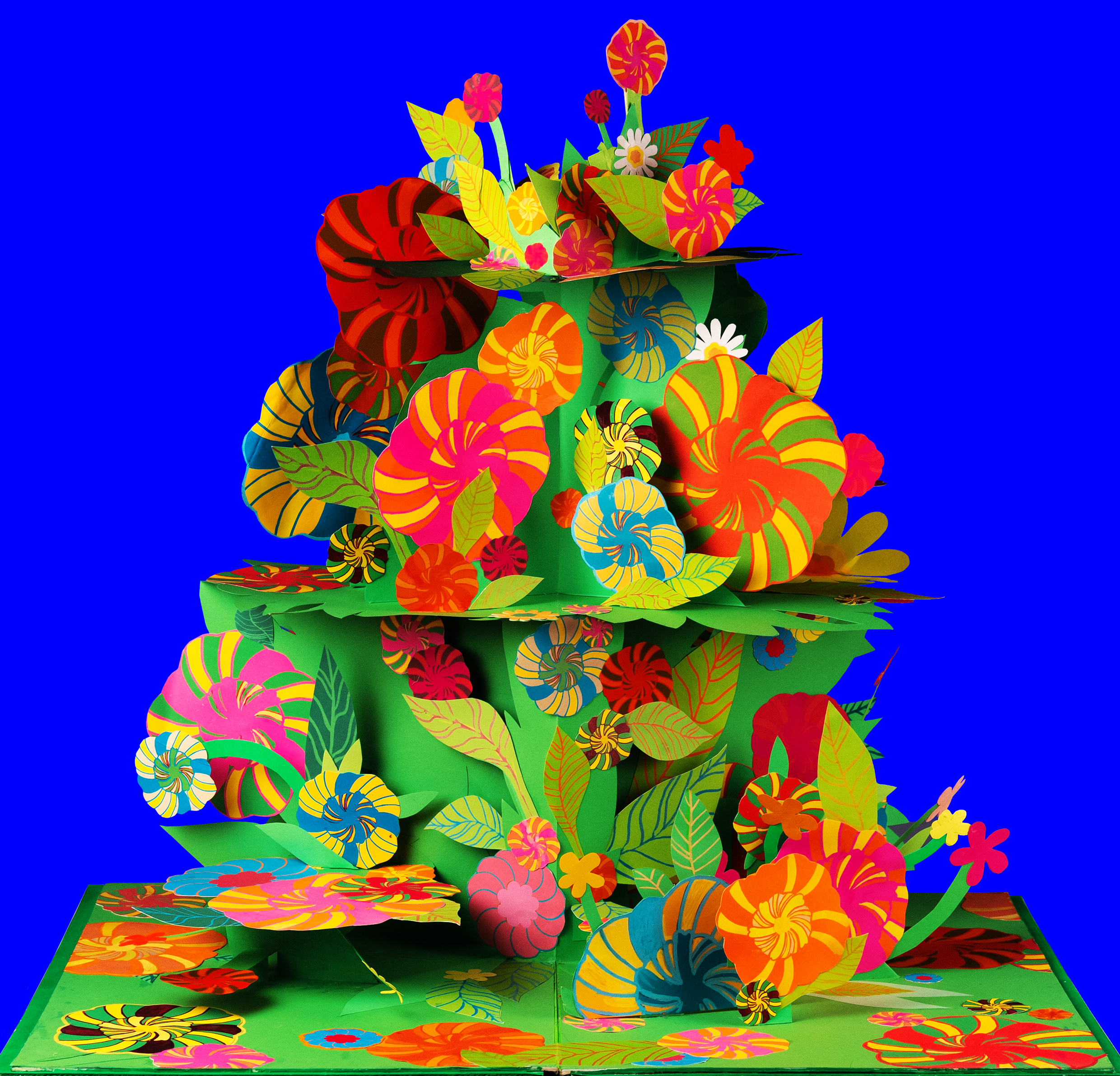 Ett mönster av papper med former av blommor och blad i olika färger. 