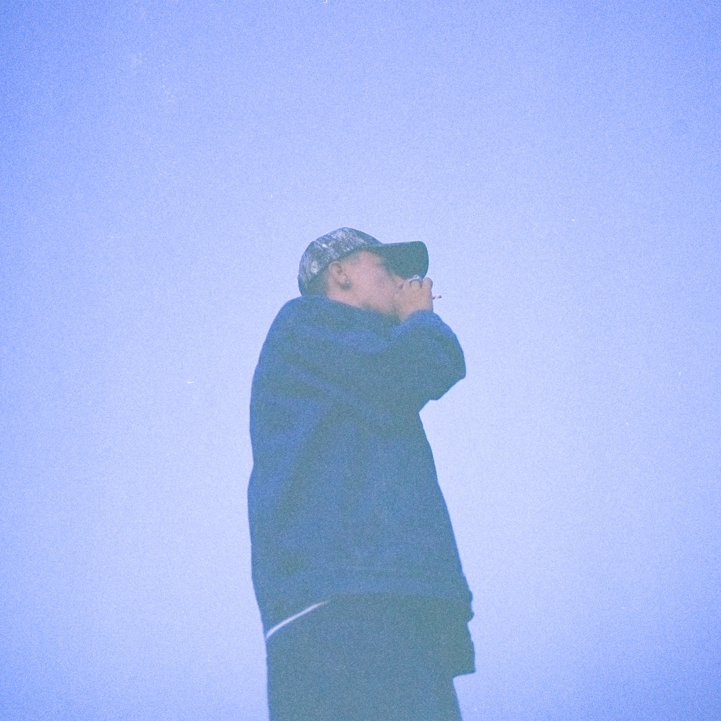 En man i keps fotad i blått ljus