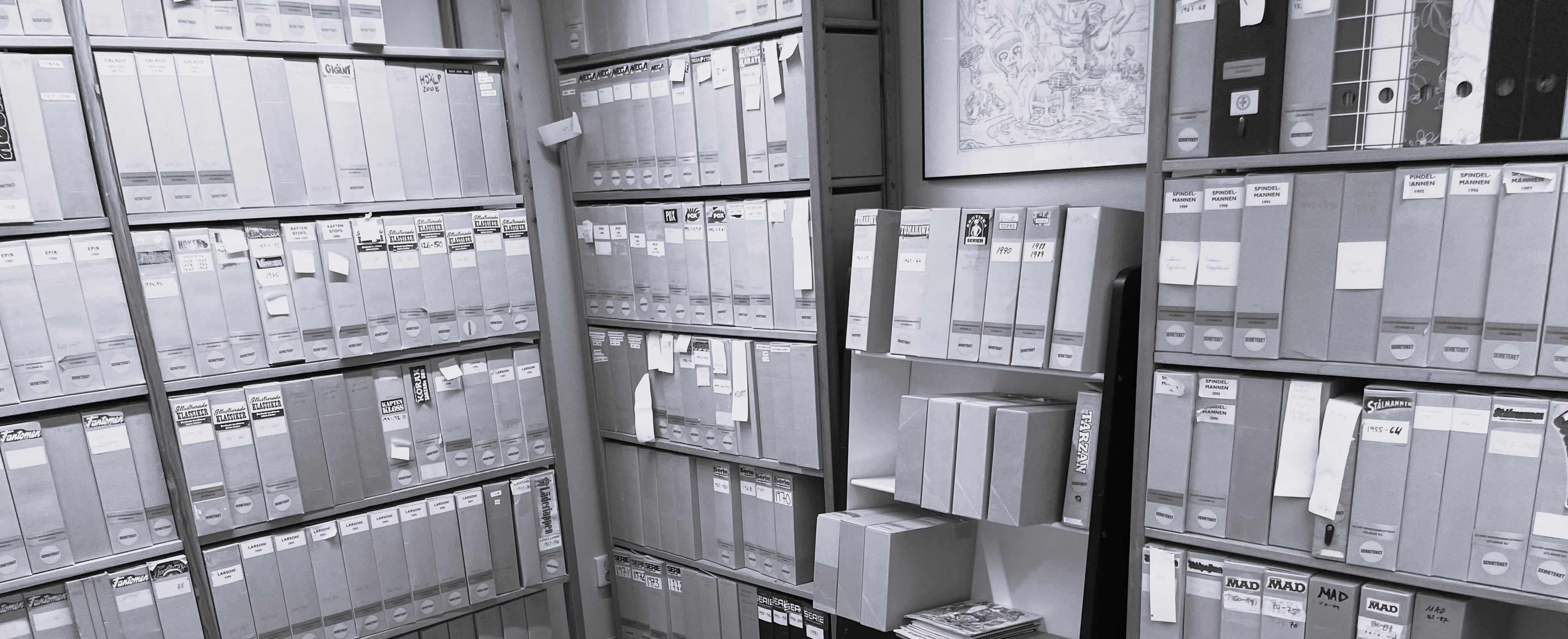 Arkivrum med hyllor fyllda av märkta tidskriftssamlare och pärmar i flera rader.