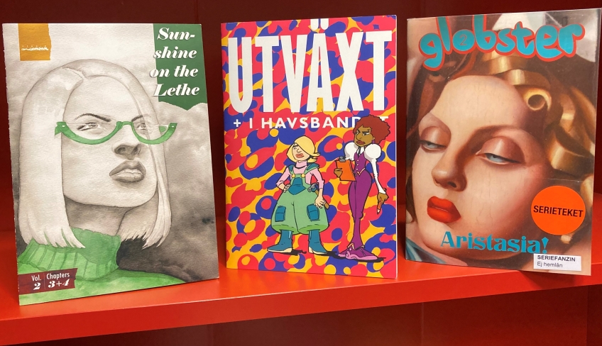 Flera seriealbum placerade i en bokhylla. 