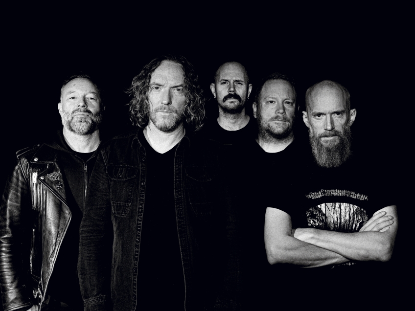 Fem män står bredvid varandra i mörker