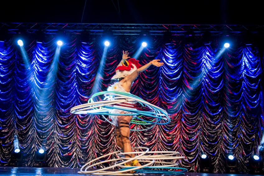 Person iklädd kyckligdräkt rockar färgglada rockringar. 