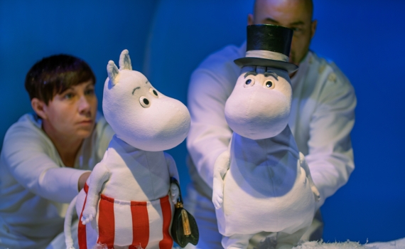 Två dockskådespelare håller i mumintroll i föreställningen Granen på Marionetteatern. 