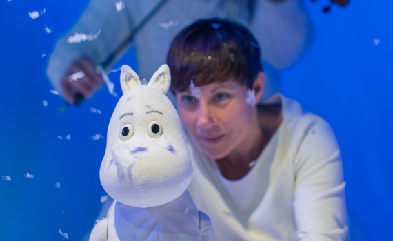 En dockskådespelare håller i en docka av ett mumintroll i föreställningen Granen. 