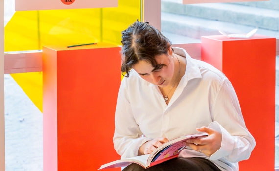 En person bläddrar i en bok i utställningen Hundra år genom tio saker. 