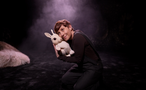 En kvinna håller om en docka som ser ut som en kanin. 