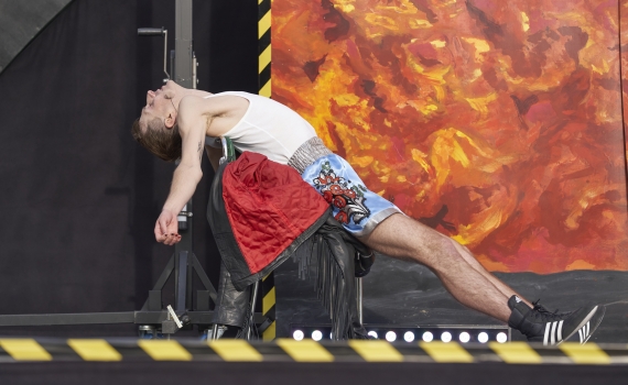 Razmus Nyström ligger utsträckt på en stol, i bakgrunden syns en fond med lavamotiv