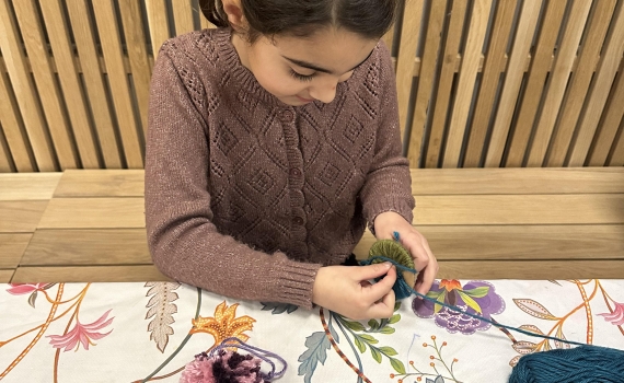 Barn pysslar med garn.