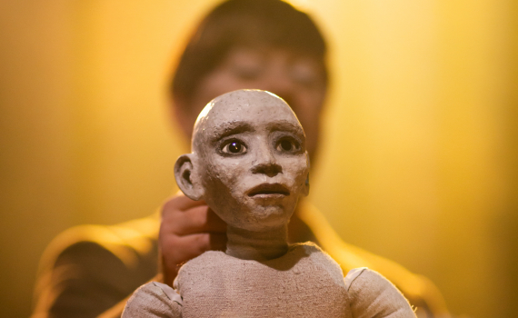 En dockskådespelare håller i en docka på Marionetteatern. 