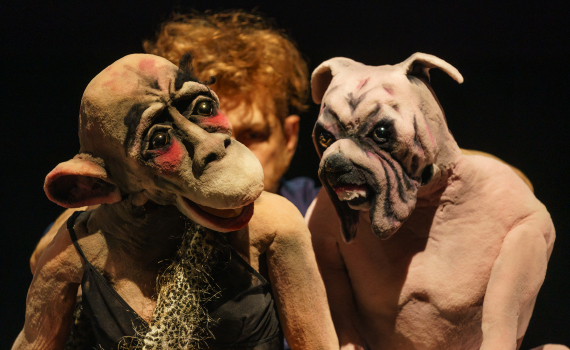 Dockor som ser ut som djur och dockskådespelare på en scen.