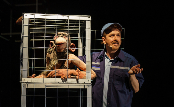 Dockor som ser ut som djur och dockskådespelare på en scen.