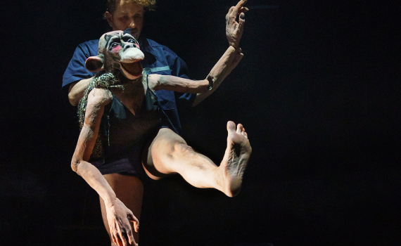 Dockor som ser ut som djur och dockskådespelare på en scen.