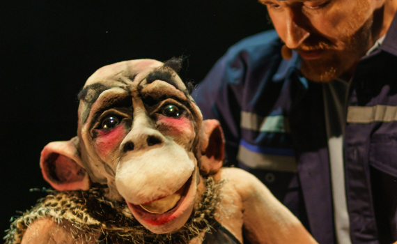 Dockor som ser ut som djur och dockskådespelare på en scen.