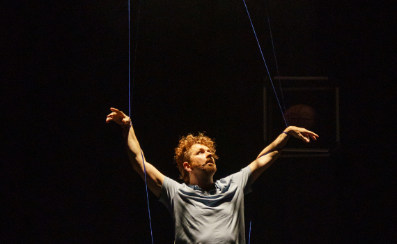 Dockor som ser ut som djur och dockskådespelare på en scen.