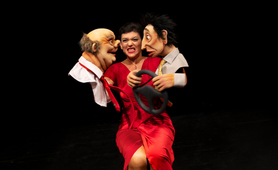 Dockskådespelare med dockor på en scen. 