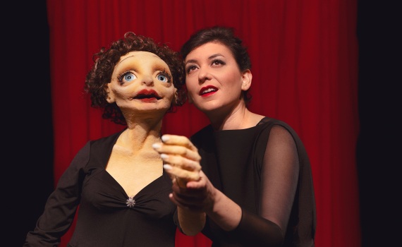 Dockskådespelare med dockor på en scen. 