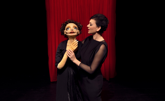 Dockskådespelare med dockor på en scen. 