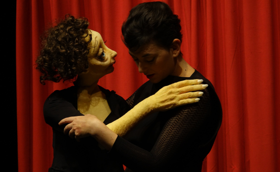 Dockskådespelare med dockor på en scen. 