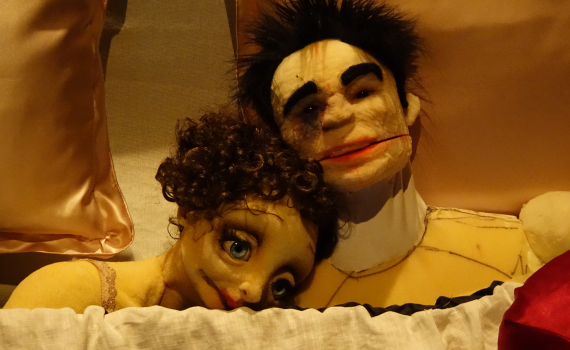 Dockskådespelare med dockor på en scen. 