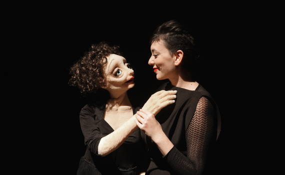 Dockskådespelare med dockor på en scen. 