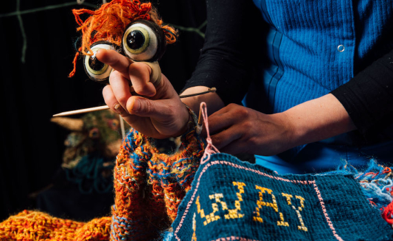 En dockskådespelare håller i en docka. 