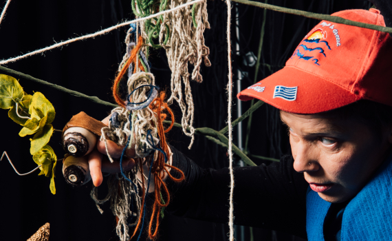 En dockskådespelare håller i flera dockor. 