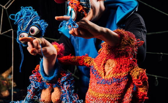 Dockskådespelare med dockor på en scen. 