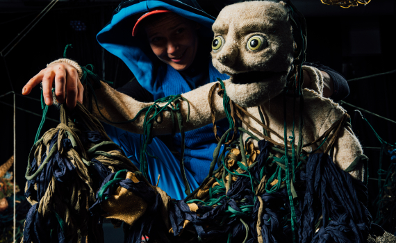 Dockskådespelare med dockor på en scen. 