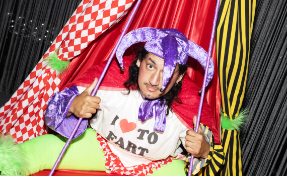 En man med jycklarhatt med bjällror och en t-shirt med texten "I LOVE TO FART".