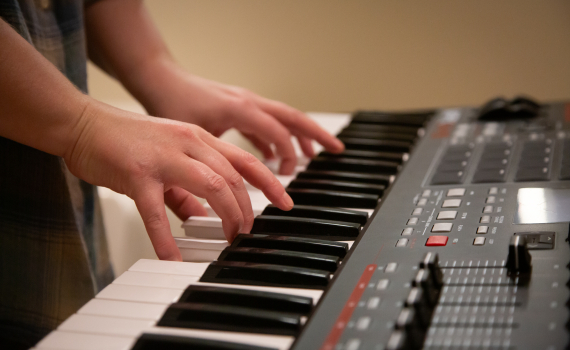 Händer som spelar på en synth