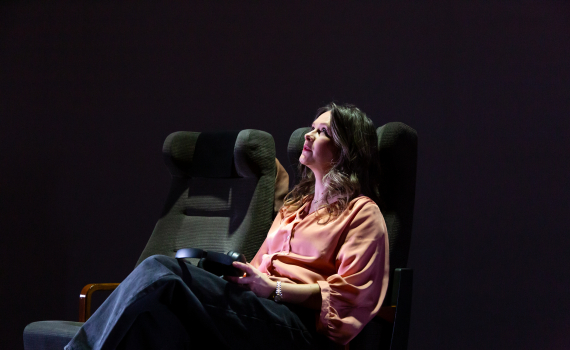 Frida Beckman i ett tågsäte med ett par hörlurar i händerna