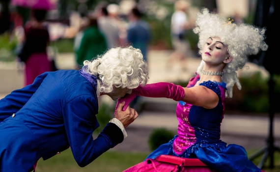 En tjänare som kysser en av drottningarnas händer