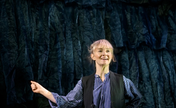 Sofia Pekkari sitter på ett par lådor och knäpper fingrarna