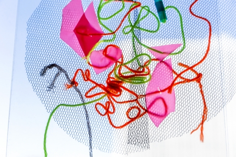 Ett mönster av trådar, tygbitar och pappersbitar. 