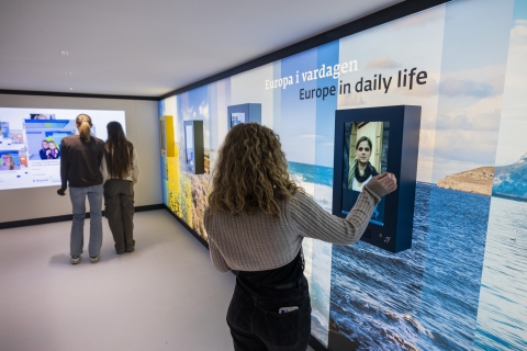 Ungdomar tittar på skärmar med information om EU.