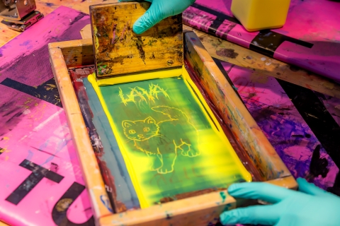 En person jobbar med screentryck. 