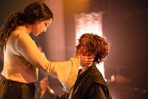 Två personer på scen, den ena håller sina händer mot den andres kind. 