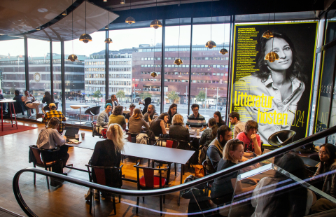 En grupp människor med olika bakgrunder samtalar runt ett bord på ett språkcafé.