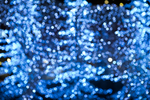 En suddig bild av lysande blå julbelysning i ett trädliknande mönster. En abstrakt och magisk känsla av vinter och fest.