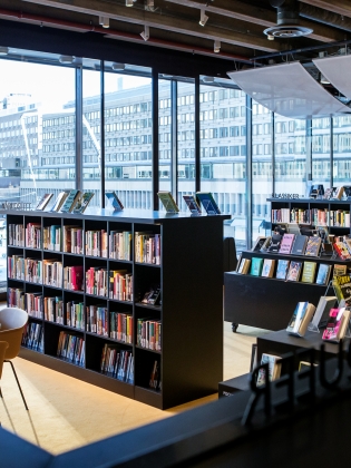Bokhyllor i Kulturbiblioteket, med utsikt mot Glasobelisken vid Sergels torg.  