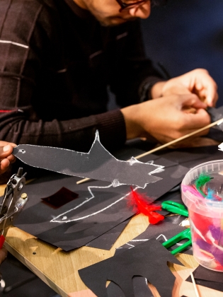 Barn och vuxna skapar figurer tillsammans. 