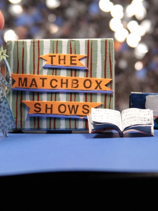 En bok, en ambulans och en figur i miniatyr. 