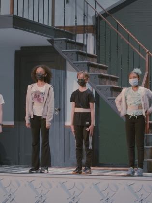 En grupp barn står på en teaterscen