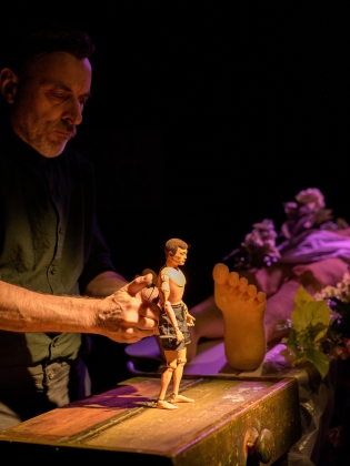 En dockskådespelare håller i en liten docka. 